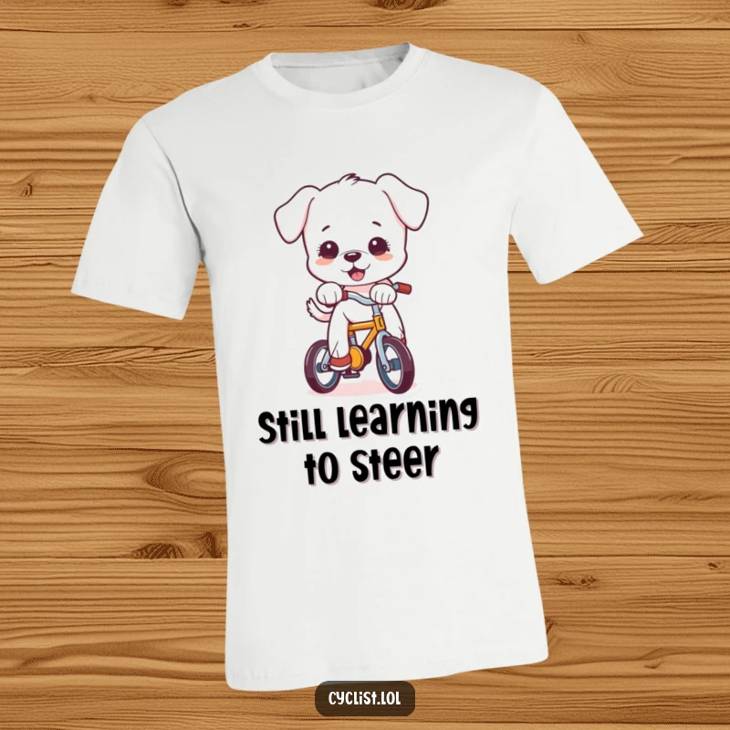 Funny cartoon puppy hilariously losing balance on a miniature bicycle, printed on a soft t-shirt, ideal for humor enthusiasts.
